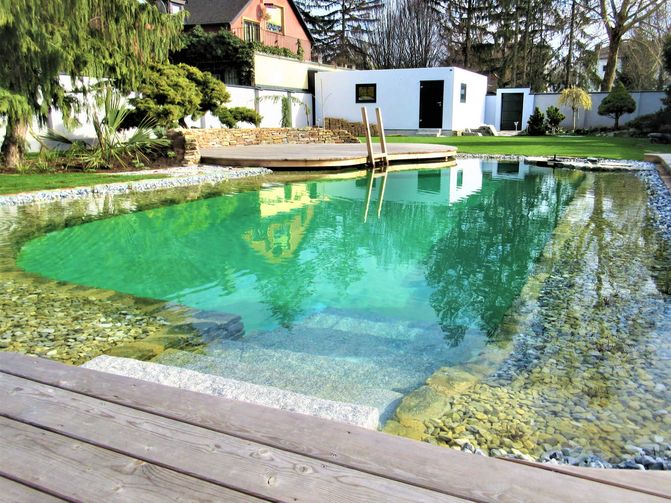 Ein großer Schwimmteich im Frühling mitten im Garten. 