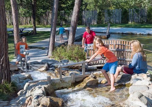 Wasserspiele im Bachlauf – Kinder kühlen sich ab.