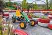 Ein Gokart steht auf der Fahrbahn der Gokartbahn, umgeben von bepflanzten und rot-weiß bemalten Reifen.